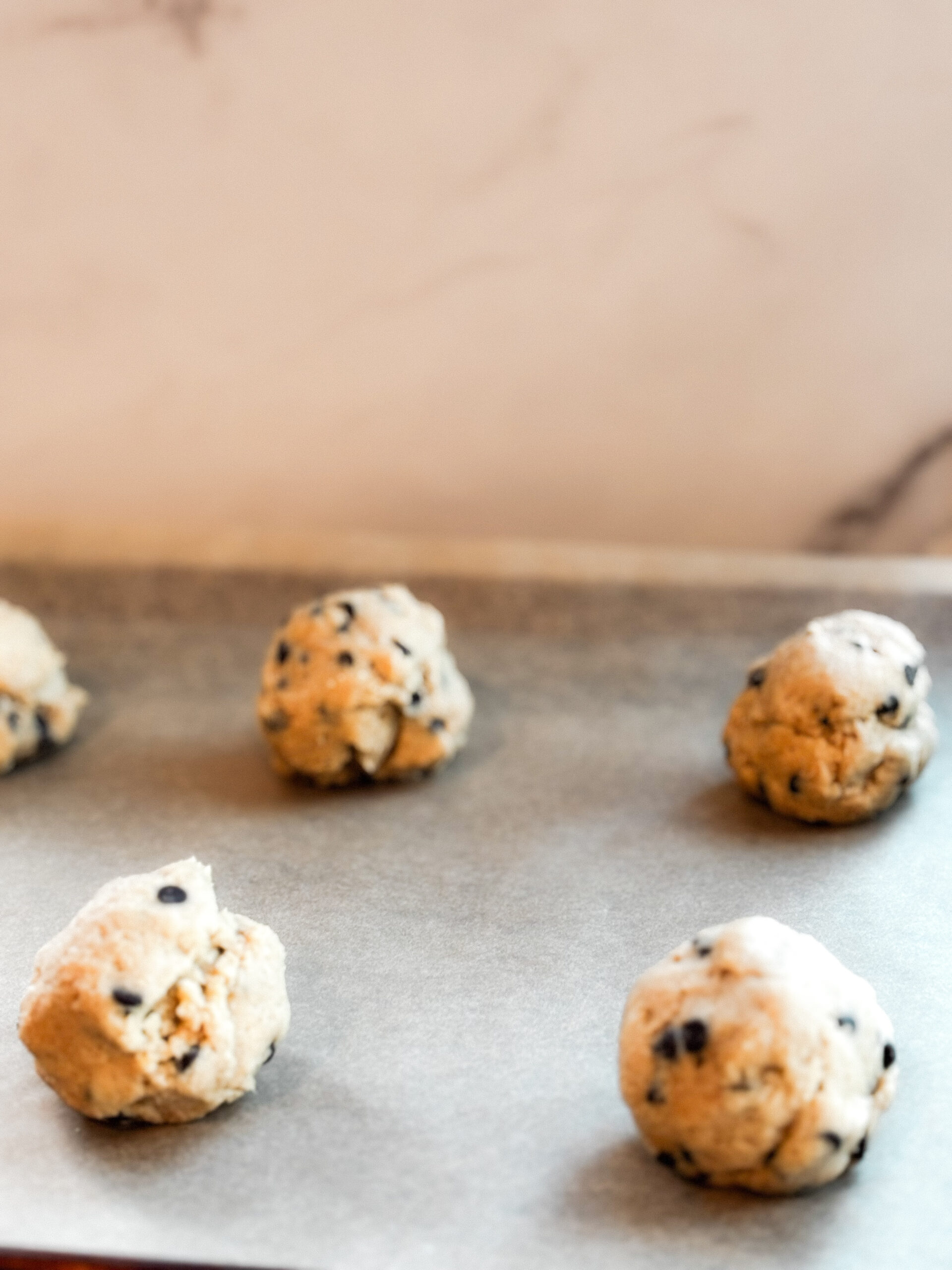 Five cookie dough balls ready to bake