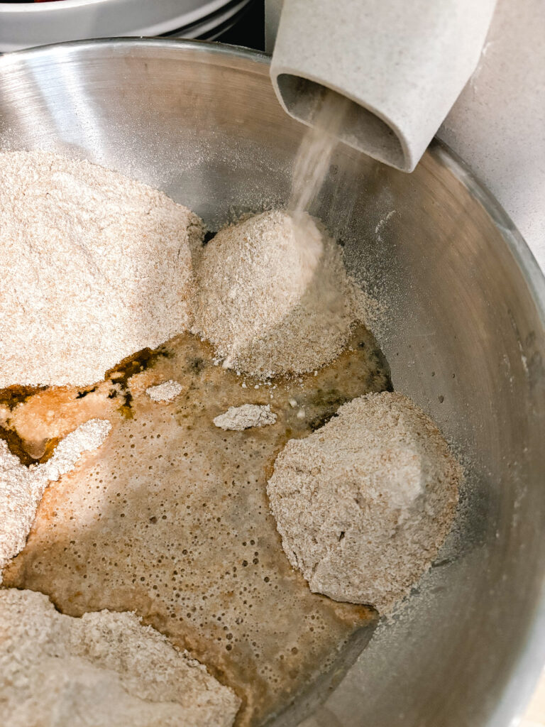 Freshly milled flour milling into a bowl of honey wheat bread ingredients