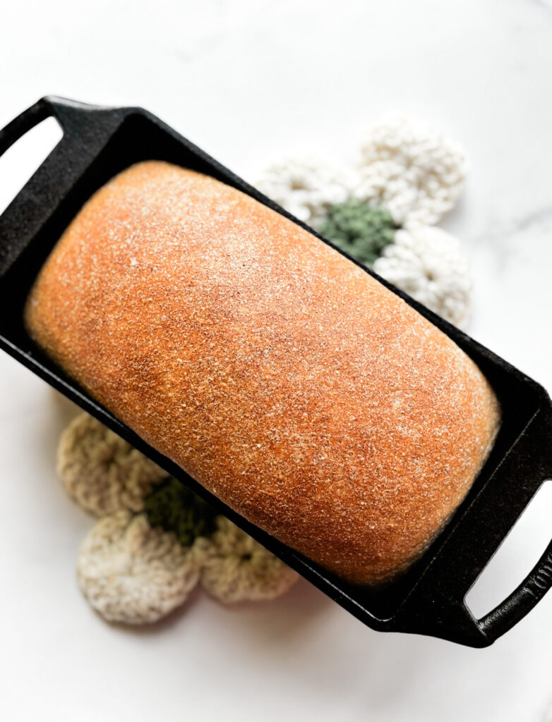 Fresh loaf of honey wheat bread on a white table